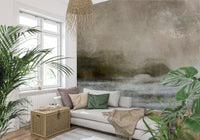 Ethereal Shoreline wallpaper mural, misty taupe horizon landscape on a wall behind a grey sofa and leafy plants