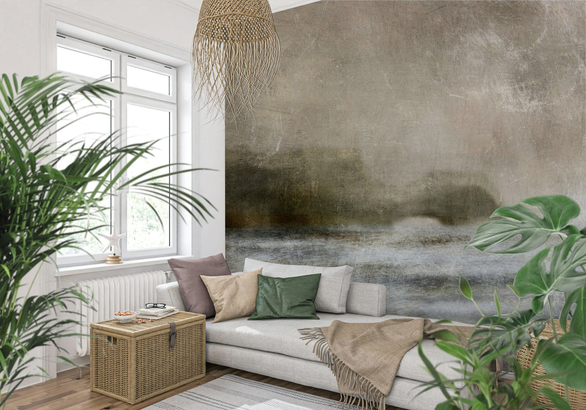 Ethereal Shoreline wallpaper mural, misty taupe horizon landscape on a wall behind a grey sofa and leafy plants