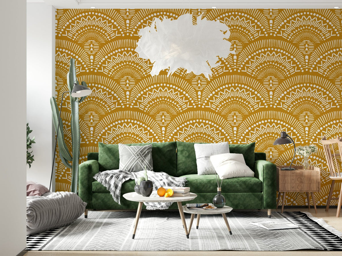 Ethnic Echoes wallpaper in mustard and white boho fans behind a dark green velvet sofa in a living room