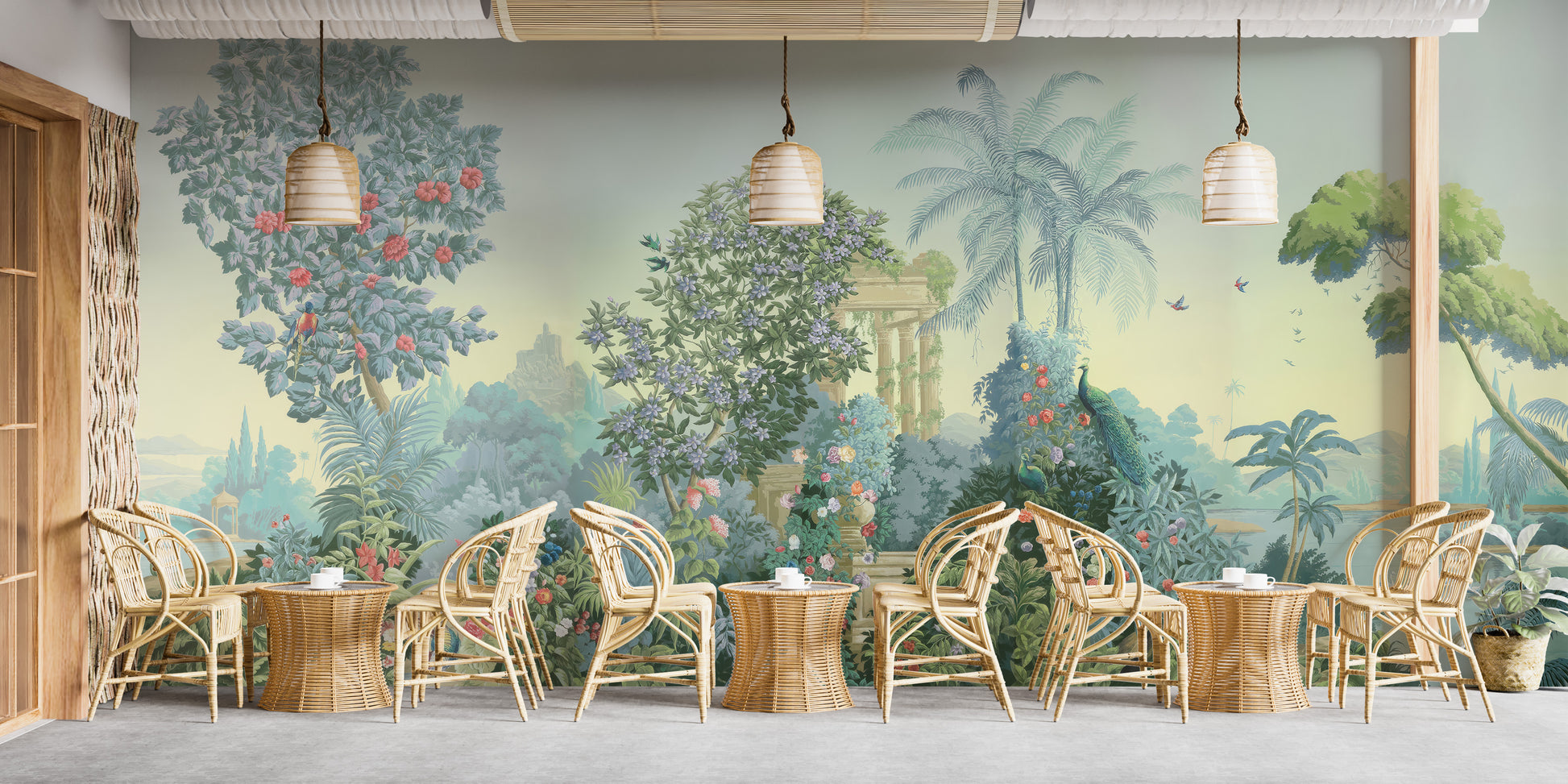 Exotic Paradise wallpaper mural of palms, flowers and peacocks in green tones behind rattan chairs and tables in a cafe setting
