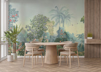 Exotic Paradise wallpaper mural with palms, peacocks and classical ruins in sage green behind a round wood dining table and beige chairs