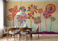 Whimsical Fantasy Flowers wallpaper mural of bold pink and yellow stylized blooms behind a wood dining table and grey chairs
