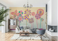 Whimsical Fantasy Flowers wallpaper mural of colourful blooms behind a grey sofa and blue swivel chair in a modern living room