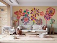 Whimsical Fantasy Flowers wallpaper mural of vivid blooms behind a grey sofa and white rattan chair in a living room