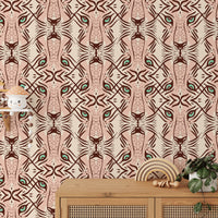 Feline Gaze Whimsical wallpaper with repeating leopard faces in blush pink and terracotta shown as a close-up pattern