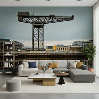 Finnieston Crane wall mural of the Glasgow waterfront above a gray sectional sofa with mustard pillows