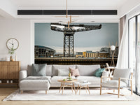 Finnieston Crane wall mural of the Clydeport crane behind a cream sectional sofa under a sculptural chandelier