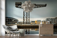 Finnieston Crane wall mural of the Clydeport crane behind woven chairs, a wood dresser and disc chandelier
