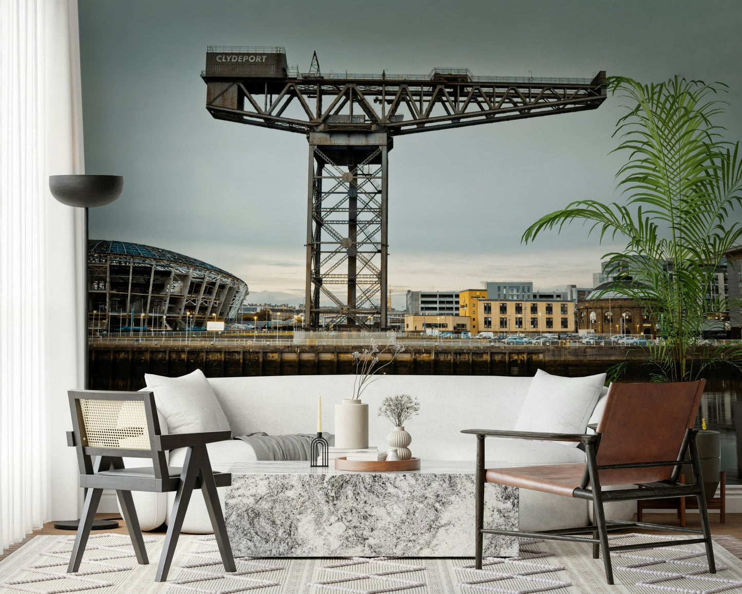 Finnieston Crane wall mural of the Glasgow waterfront behind a white sofa with cane and leather chairs