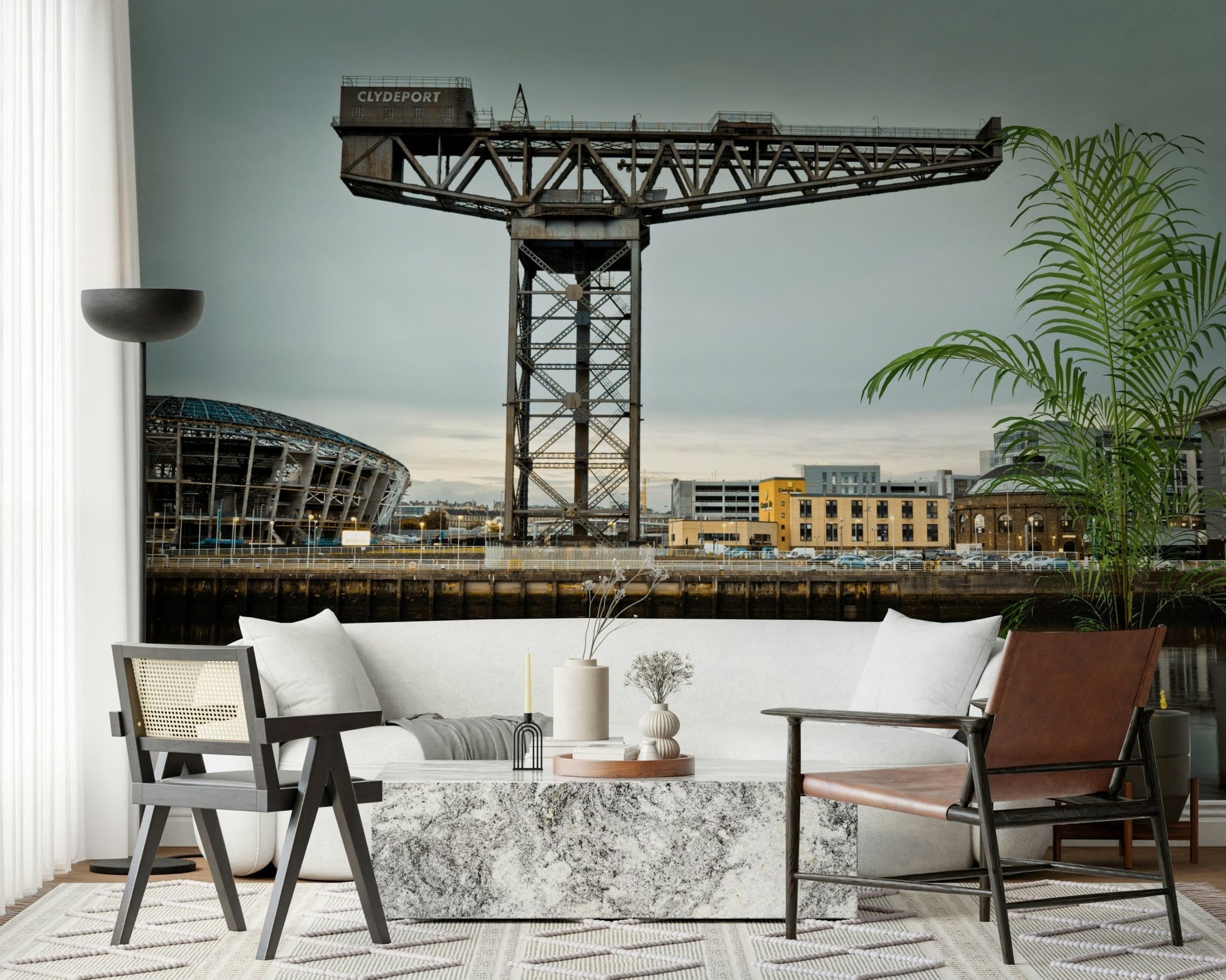 Finnieston Crane wall mural of the Glasgow waterfront behind a white sofa with cane and leather chairs