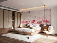 Flamingo wallpaper of pink flamingos above a white bed with wood-panel wardrobes and a rattan armchair in a bedroom