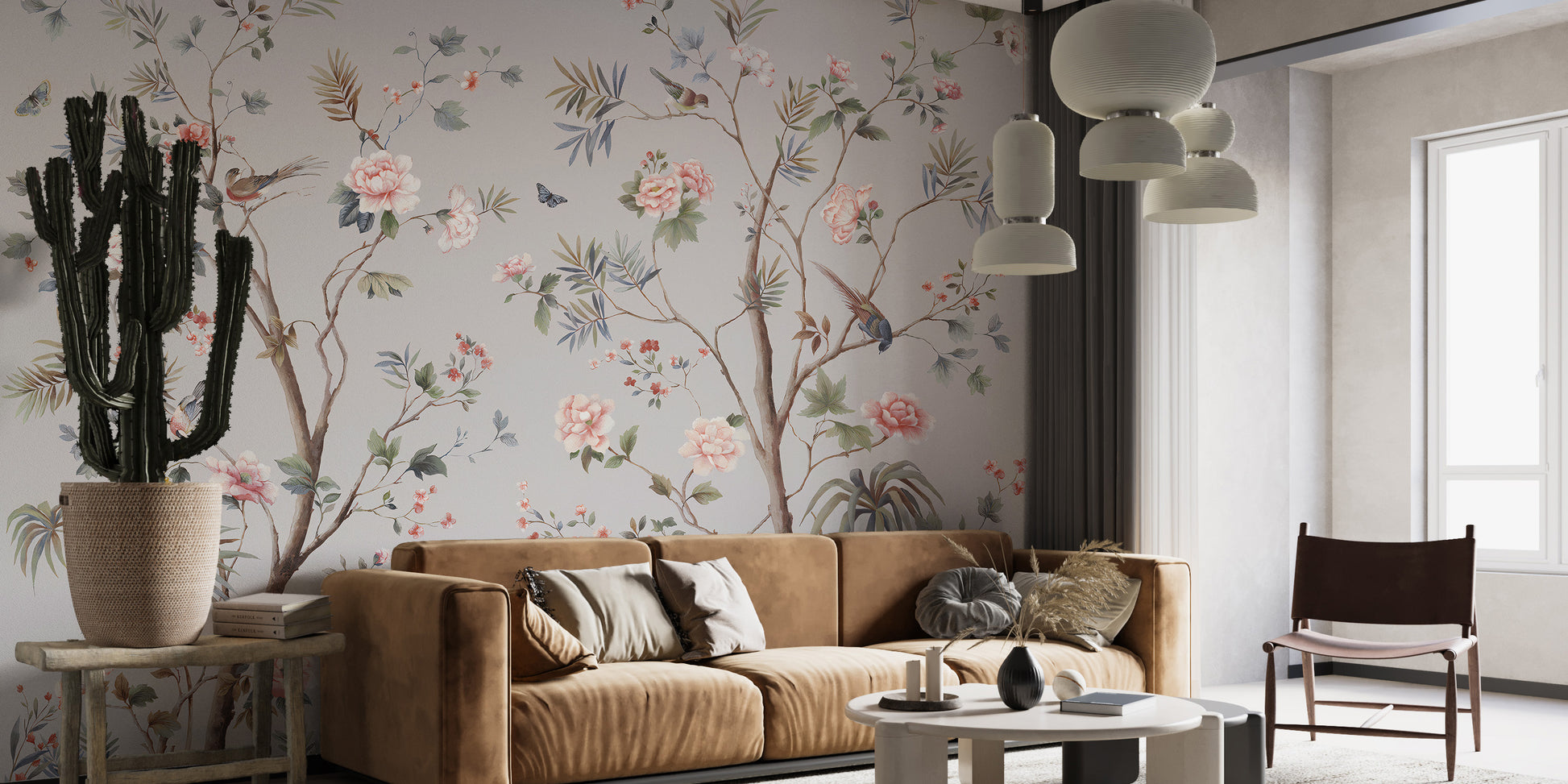Chinoeserie Floral design wallpaper mural with pink peonies and birds behind a camel sofa and cactus in a living room