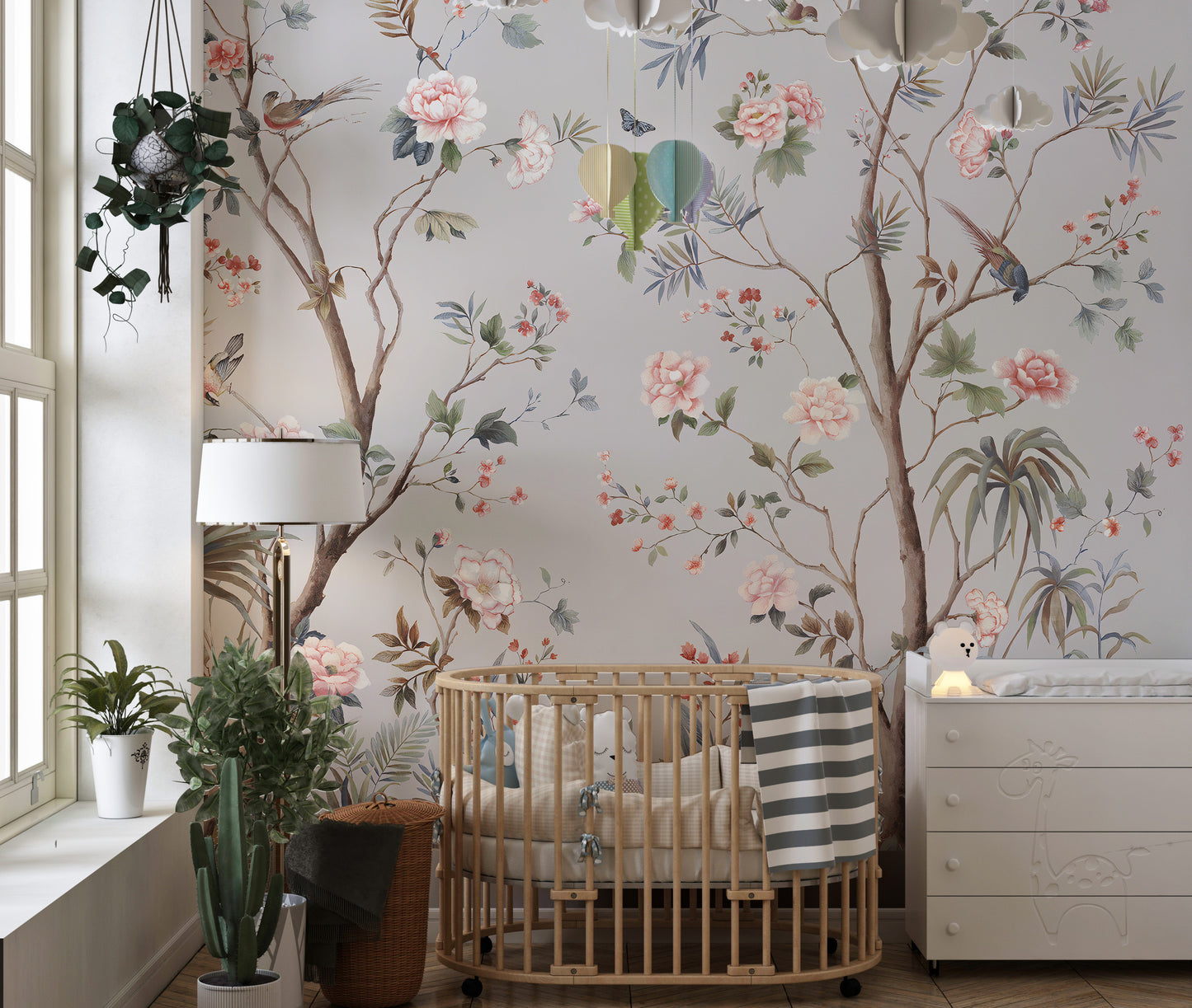 Chinoeserie Floral design wallpaper mural in gray with pink blooms and birds behind a wooden crib in a nursery