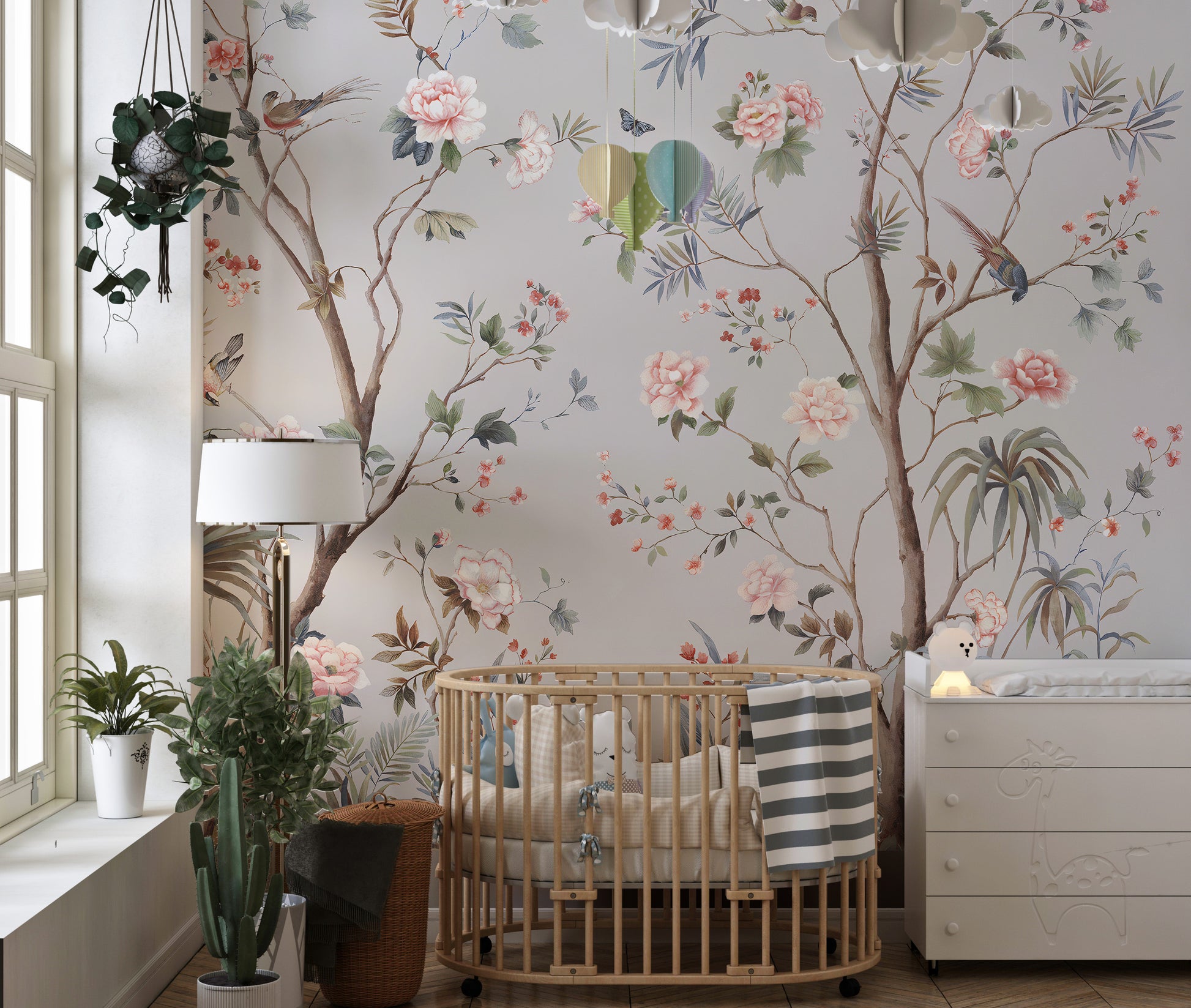 Chinoeserie Floral design wallpaper mural in gray with pink blooms and birds behind a wooden crib in a nursery