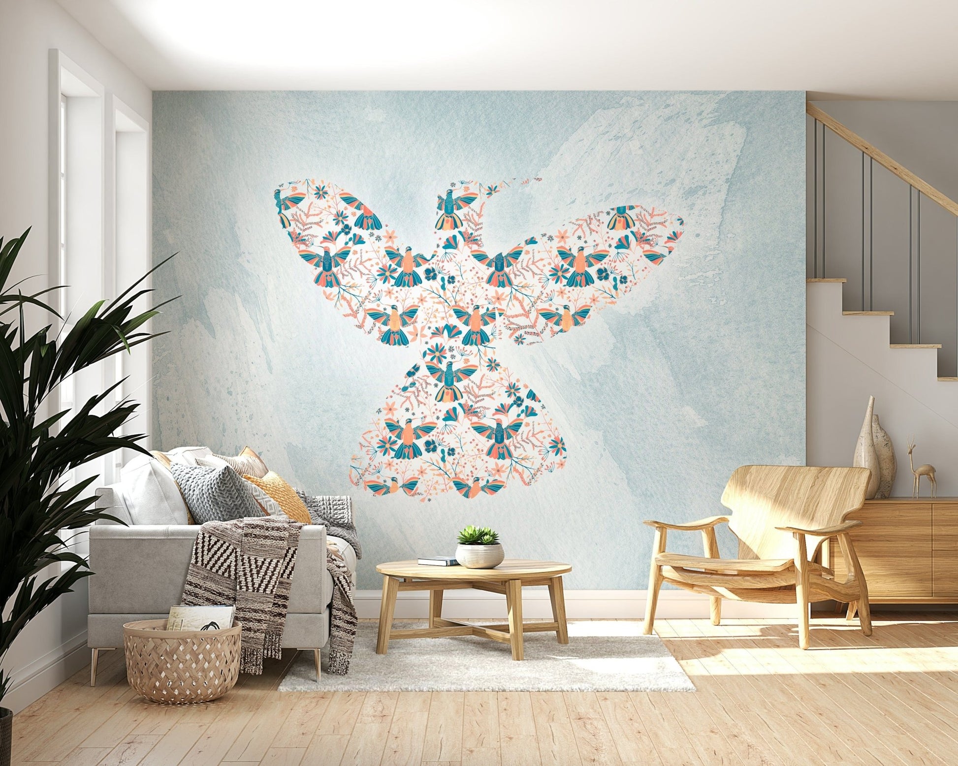 Floral Hummingbird wall mural in coral and teal on blue behind a grey sofa in a living room