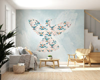 Floral Hummingbird wall mural in coral and teal on blue behind a grey sofa in a living room