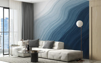 Fluid Blue Gradient Watercolor wallpaper mural behind a cream sectional sofa and globe floor lamp in a living room