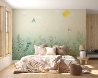 Butterfly meadow pastel wall mural on canvas material in a cozy bedroom featuring a brown throw and white pillows.