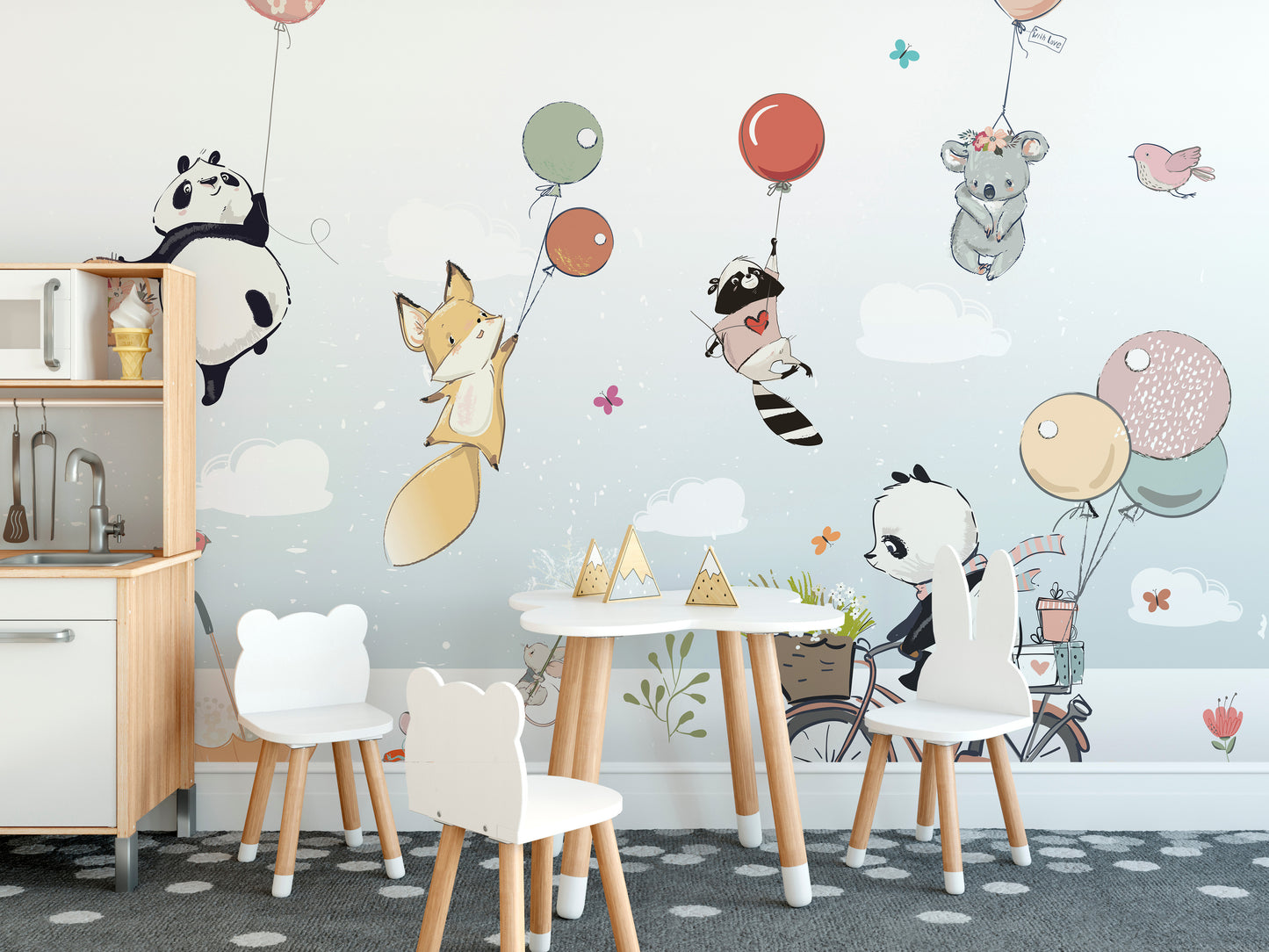 Flying Animals with Balloons mural above a white play kitchen and bear-shaped chairs in a kids playroom