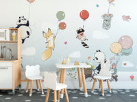 Flying Animals with Balloons mural above a white play kitchen and bear-shaped chairs in a kids playroom