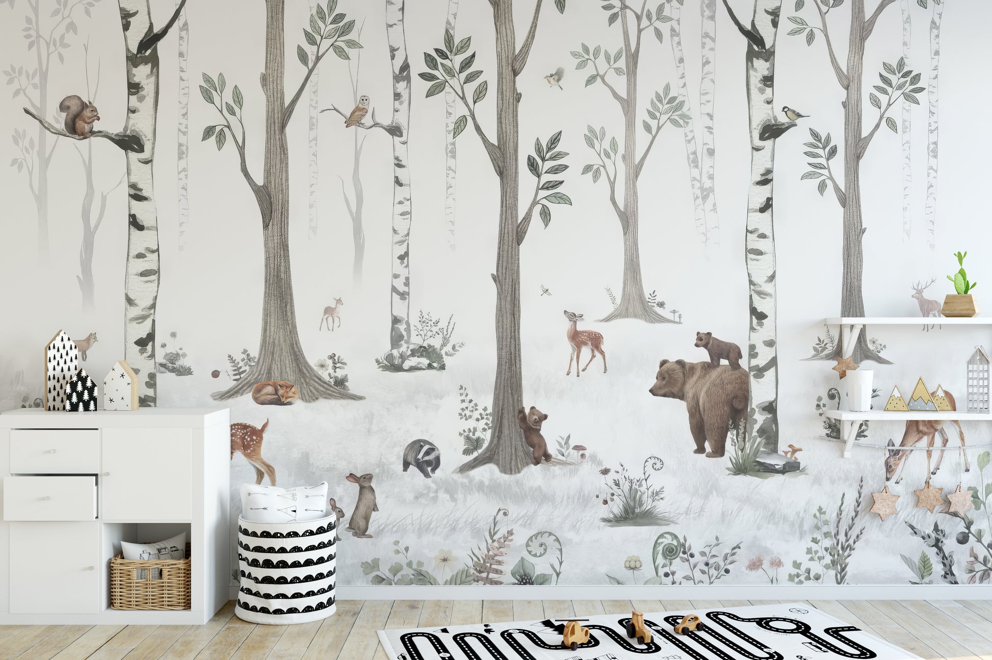 Forest Haven wallpaper mural of woodland animals in birch trees behind a white dresser and shelves in a kids room