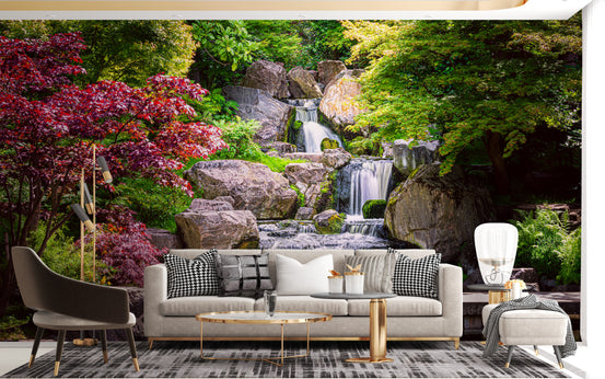 Garden waterfall mural with cascading falls and red Japanese maple trees on a living room wall behind a cream sofa
