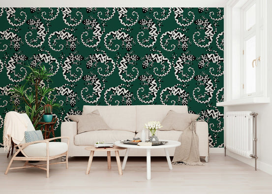 Gecko Groove wallpaper in green with white geckos behind a beige sofa and wood armchair in a living room