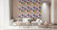 Geometric Forest Harmony wallpaper of mid-century triangles behind a cream sectional and round wood tables