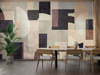 Modern Abstract wallpaper mural in soft neutral and charcoal shapes behind a wooden dining table and chairs with a tall palm