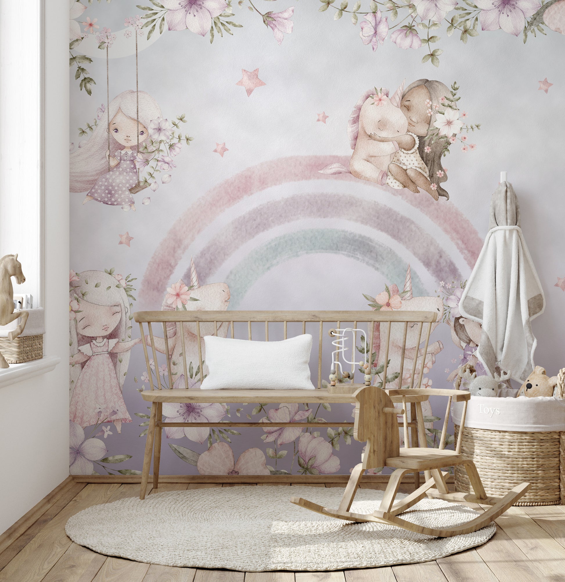 Whimsical Rainbow wall mural in a pastel nursery with a wood bench, rocking chair and round woven rug