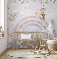 Whimsical Rainbow wall mural in a pastel nursery with a wood bench, rocking chair and round woven rug