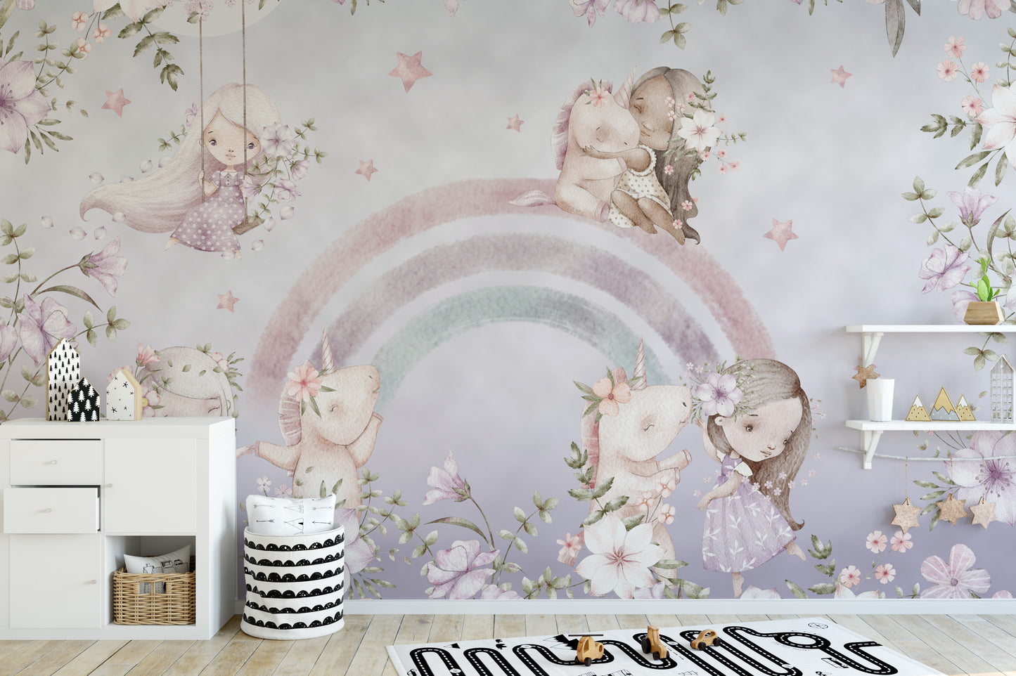 Whimsical Rainbow wall mural of pink unicorns and flowers above a white dresser in a soft pastel kids room