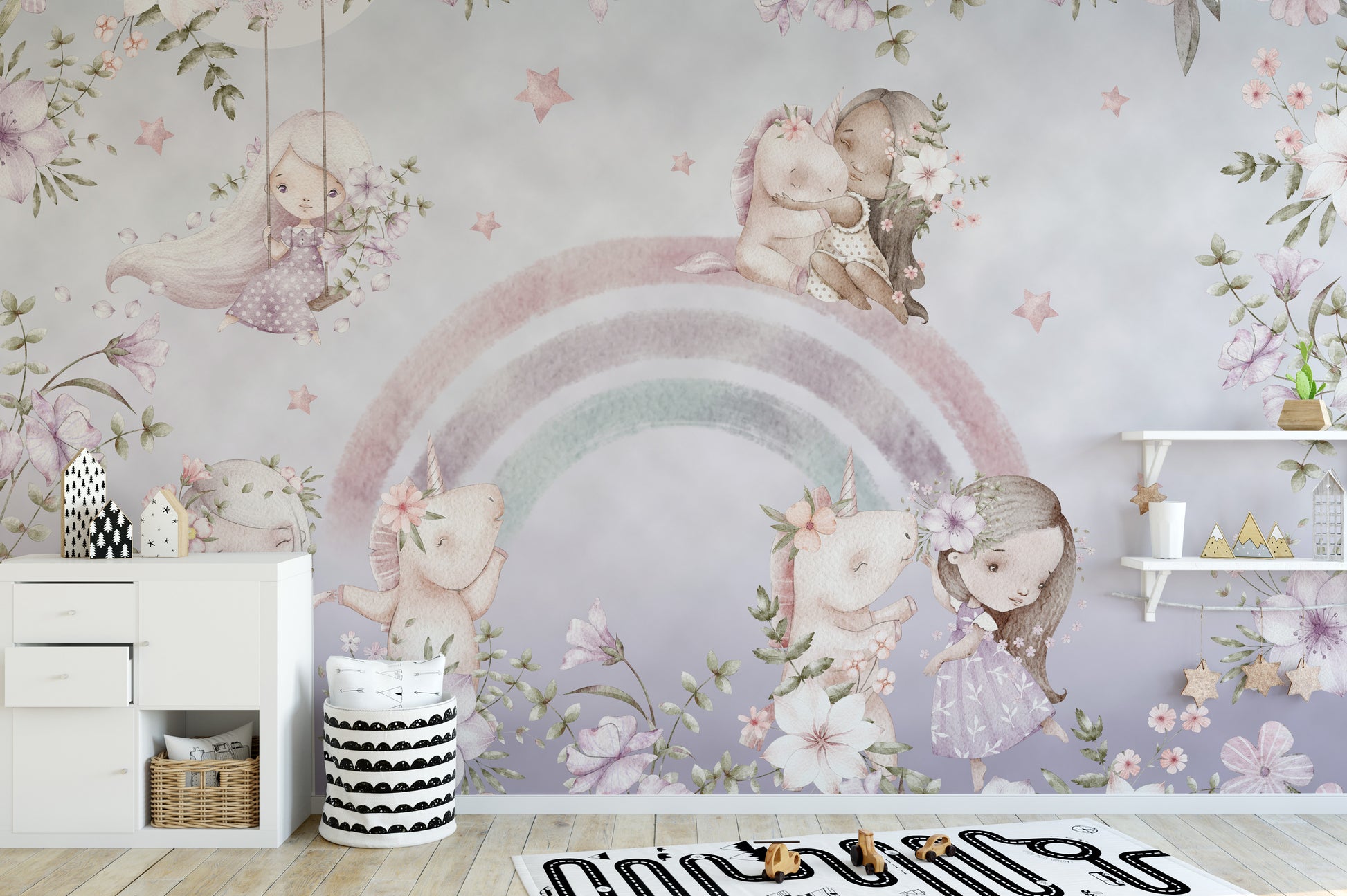 Whimsical Rainbow wall mural of pink unicorns and flowers above a white dresser in a soft pastel kids room