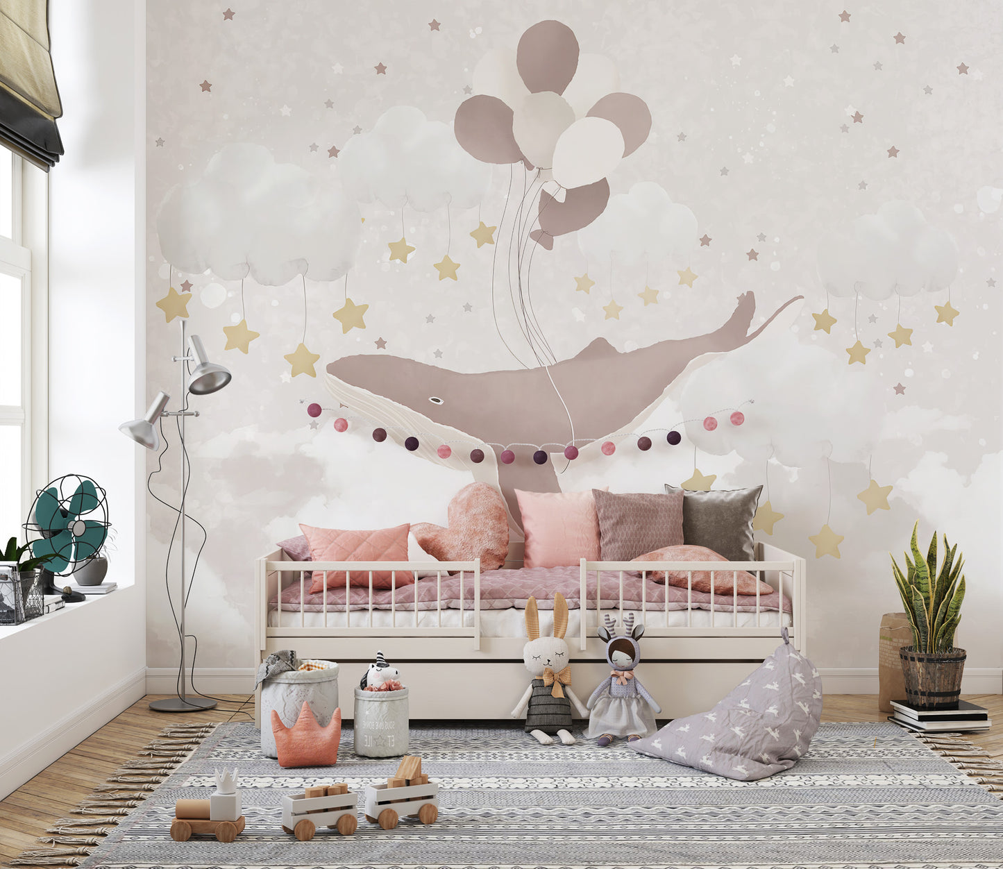 Whale Sky Parade wallpaper mural with a balloon-lifted whale above a cream nursery daybed with pink pillows