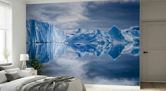 Frozen Dreams wallpaper mural of blue icebergs reflected in still water behind a gray bed in a bright bedroom