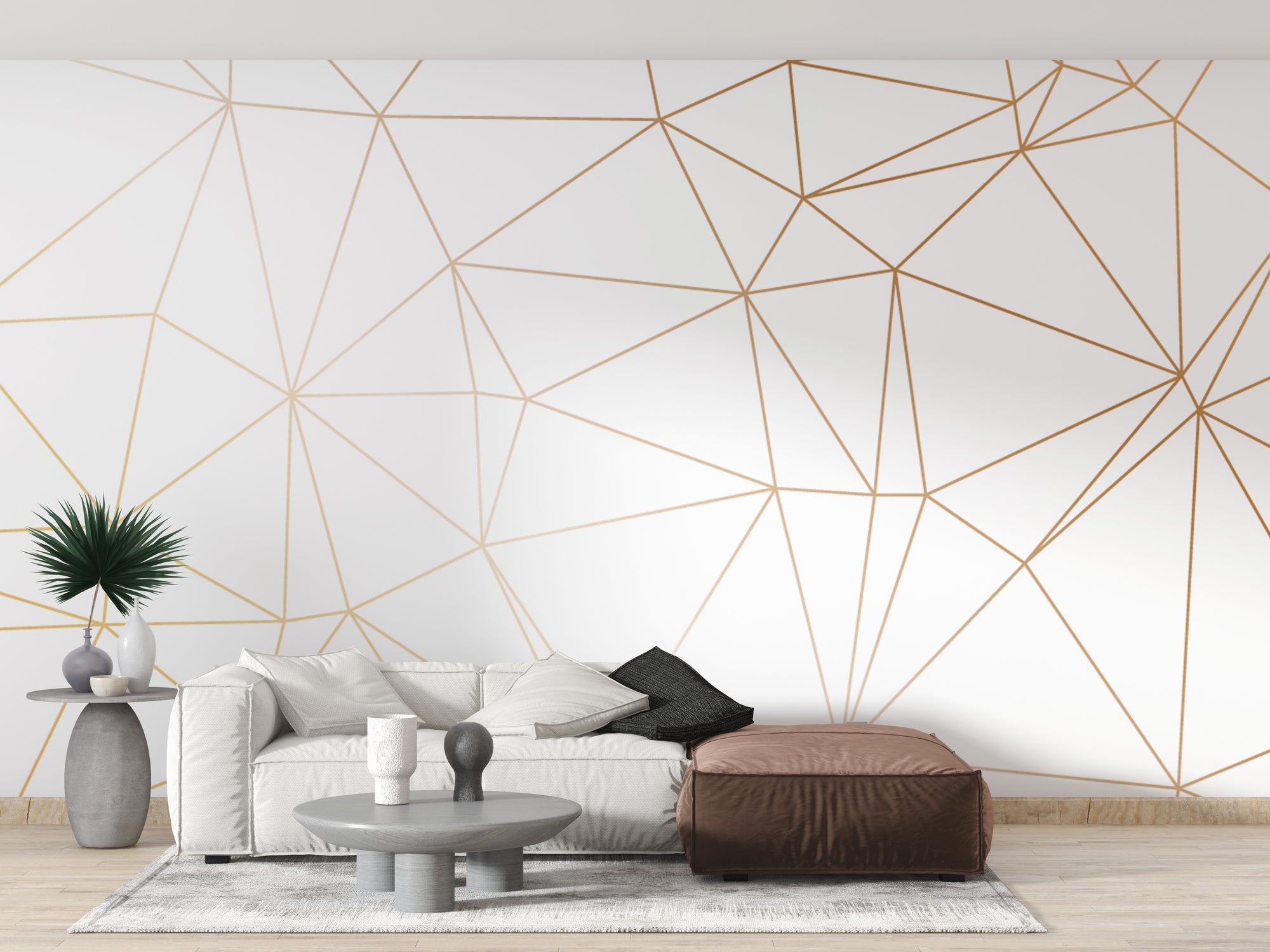 Gold Polygonal Strip Geometric wallpaper mural of gold lines on white behind a cream sofa and brown leather ottoman