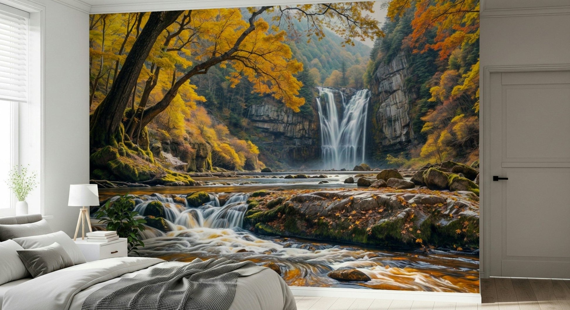 Golden Falls wallpaper mural of a waterfall and autumn forest behind a low gray bed in a bedroom