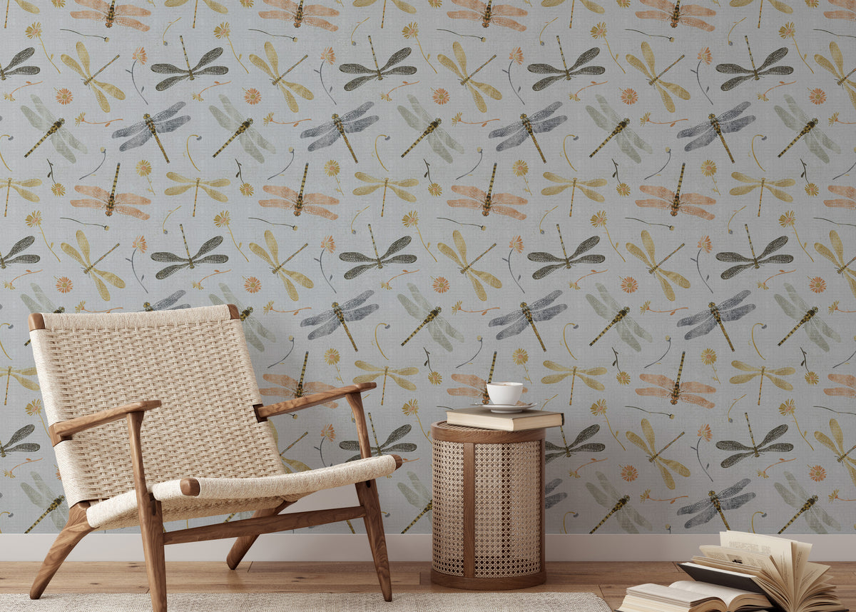 Dragonfly Damselfly Golden Gray wallpaper behind a woven rattan armchair and cane side table with a coffee cup