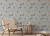 Dragonfly Damselfly Golden Gray wallpaper behind a woven rattan armchair and cane side table with a coffee cup