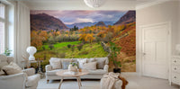 Golden Hills wallpaper mural of an autumn valley with green meadow and rugged hills at dusk behind a beige sofa in a living room