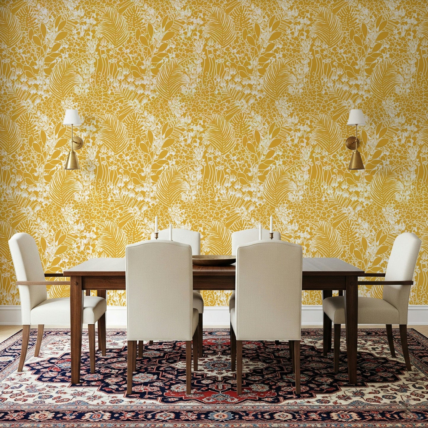 Golden Meadow Dream wallpaper in yellow behind a dark wood dining table with cream chairs and gold sconces