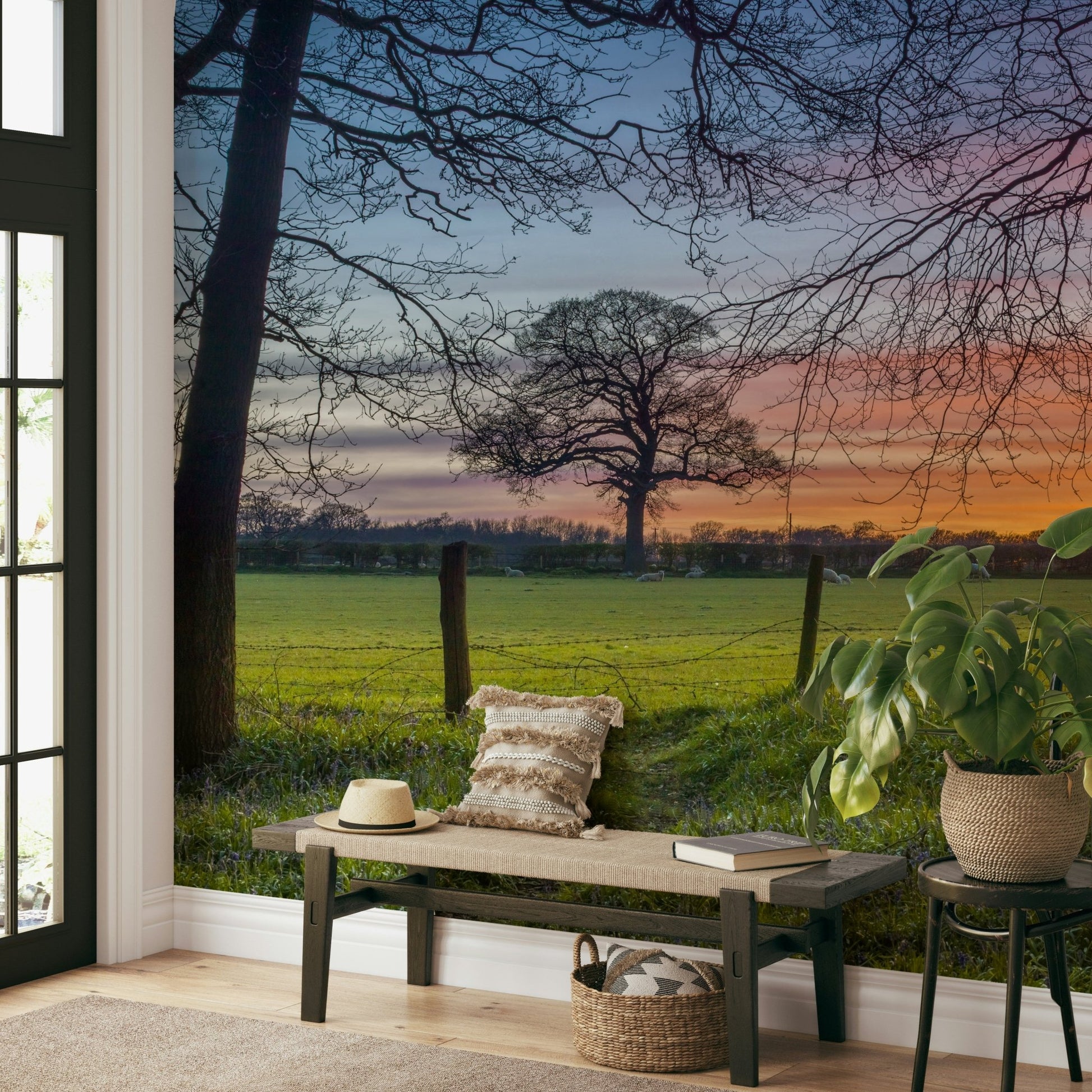 The image shows a full wall with a field of grass and flowers under a gentle, golden light.

