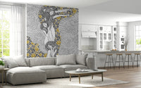 Golden Reverie wallpaper mural behind a gray sectional sofa in an open living room and kitchen