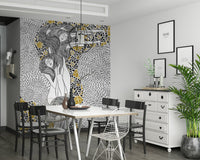 Golden Reverie wallpaper mural behind a white dining table and black chairs in a dining room