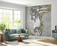 Golden Reverie wallpaper mural with gold florals behind a sage green sofa in a bright living room