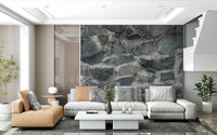 Granite Blocks wallpaper mural of grey stone behind a camel chaise and grey sectional in a living room
