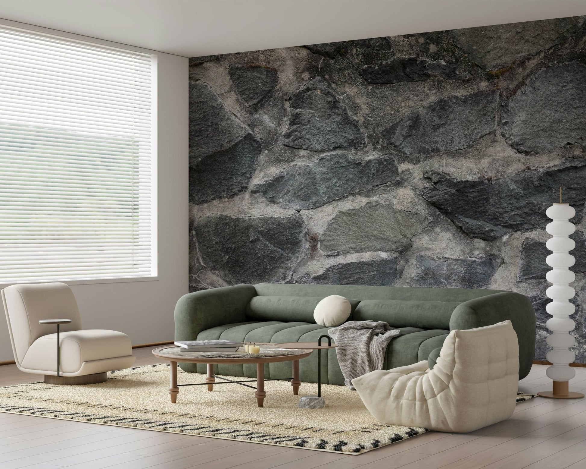 Granite Blocks wallpaper mural of grey stone behind a green sofa and cream boucle lounge chair in a living room