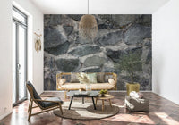 Granite Blocks wallpaper mural of grey masonry behind a rattan daybed and woven pendant over terracotta floor