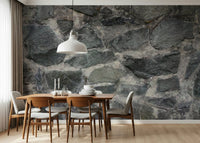 Granite Blocks wallpaper mural of grey masonry above a walnut dining table and chairs in a dining room