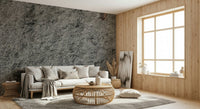 Granite Gray wallpaper mural behind a white sofa and round rattan table by a wood-panel window wall